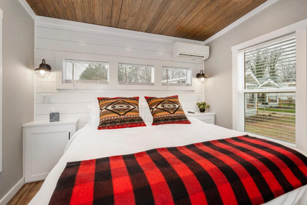 a bedroom with a bed with a red and black blanket at Carolina Camp Cedar in Pickens