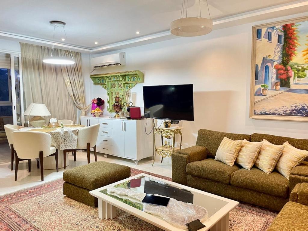 Le Chesterfield Gammarth في قمرت: غرفة معيشة بها أريكة وطاولة