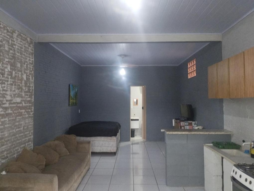 ein Wohnzimmer mit Sofa und Bett in der Unterkunft KitNet suíte Balneário shangrila in Pontal do Paraná