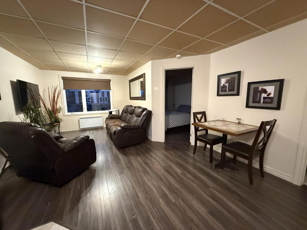a living room with a couch and a table and chairs at Apartement #4 avec chambre Baie Comeau in Baie-Comeau