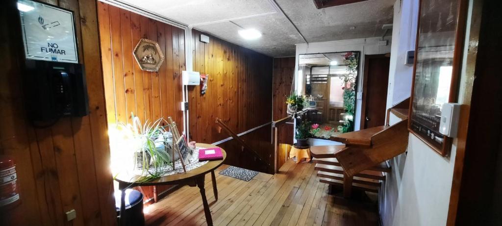 un soggiorno con un tavolo e un pianoforte di Hosteria Quellon a Quellón