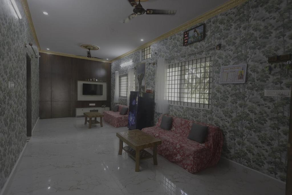 een woonkamer met twee banken en een tv bij Coconut Sooru,Managed By Triora Escapes in Maddūr