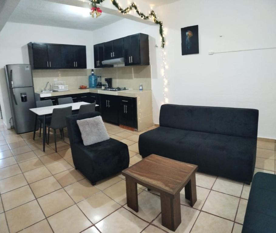 un salon avec un canapé et une table et une cuisine dans l'établissement Casa Héroes, à Cancún