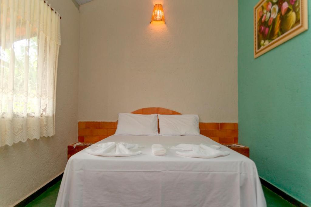a bedroom with a bed with two towels on it at Pousada Quintal da Serra in Serra do Cipo