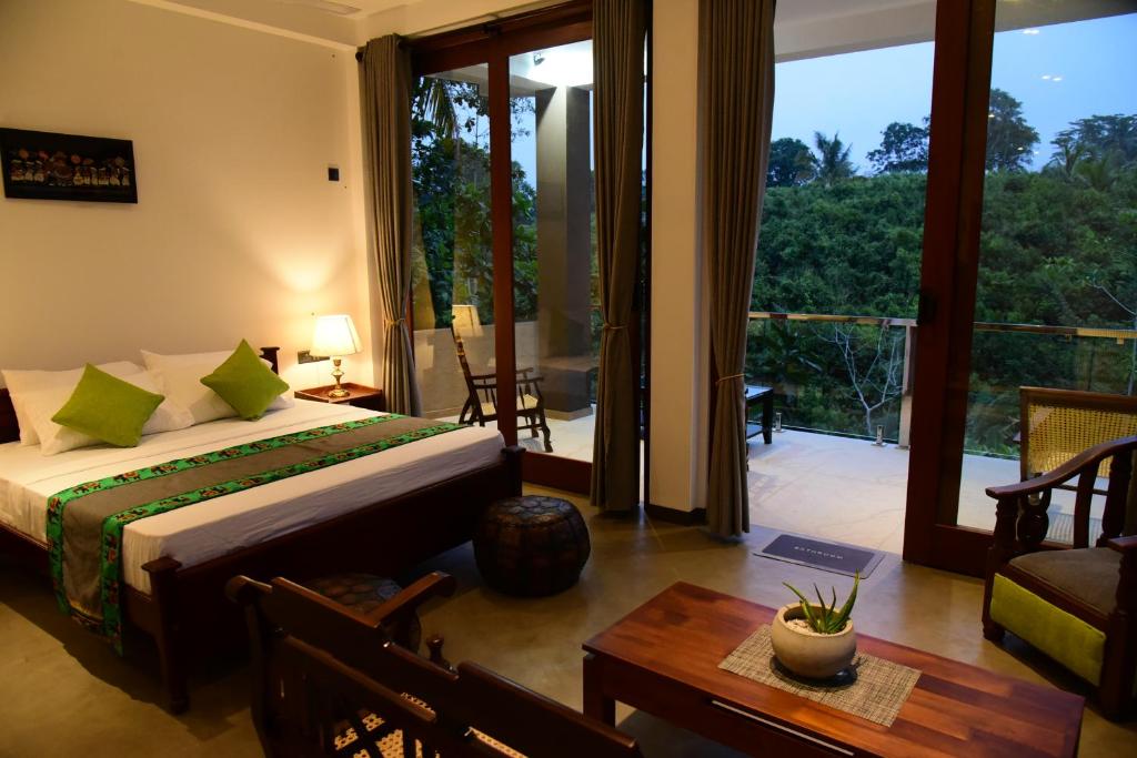 a bedroom with a bed and a view of a balcony at Moon Lanka Hotel Hikkaduwa in Hikkaduwa