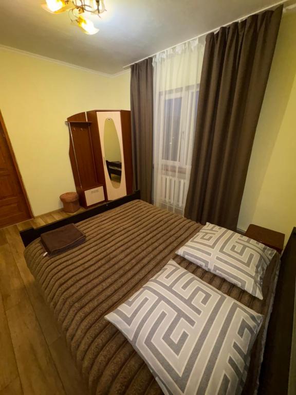 een slaapkamer met twee bedden en een spiegel bij Karpatski Prostory in Slavske