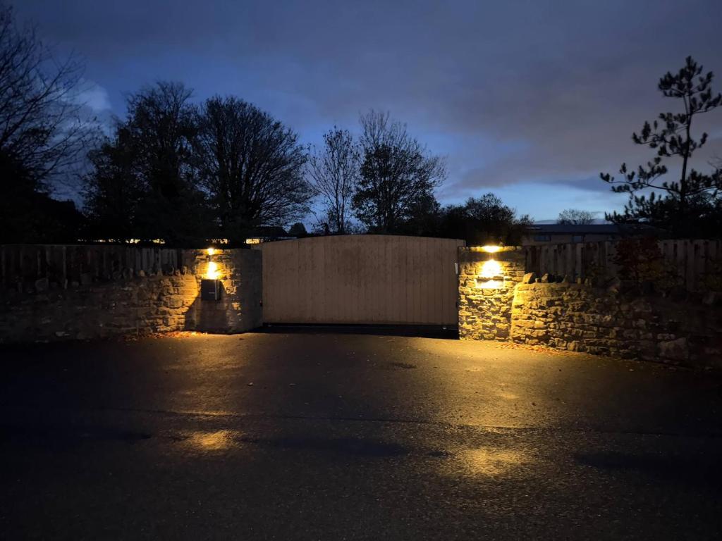 a parking lot at night with lights on a stone wall at Pine Ridge 1 in Bristol