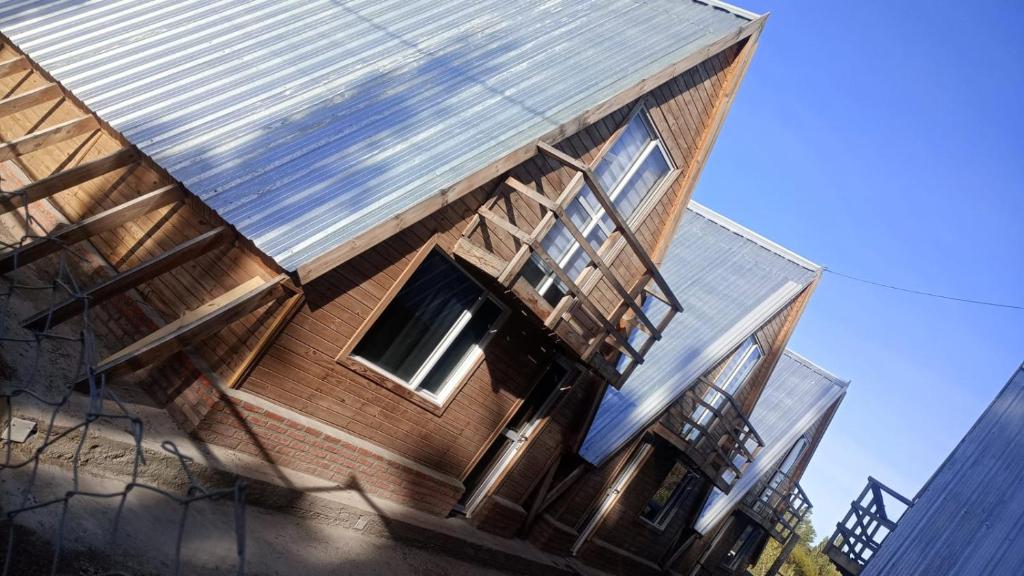 ein Gebäude mit einem Metalldach darüber in der Unterkunft Cabañas Alpinas M&M in Perito Moreno