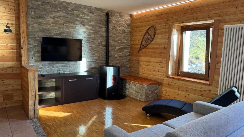 ein Wohnzimmer mit Sofa und Flachbildfernseher in der Unterkunft Trilocale sul Lago di Molveno in Molveno