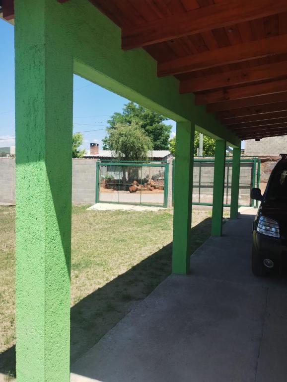 a green building with a car parked under it at Cosquin in Santa María