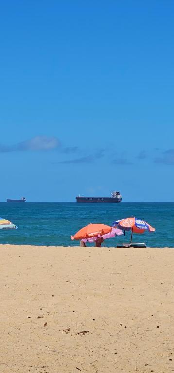 een groep parasols op een strand met de oceaan bij Apartamento temporada 2 quartos em Vila Velha in Vila Velha