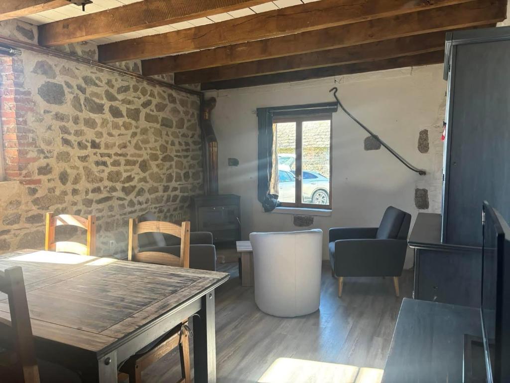 ein Raum mit einem Tisch und Stühlen und einem Fenster in der Unterkunft Maison typique Auvergne in Montel-de-Gelat