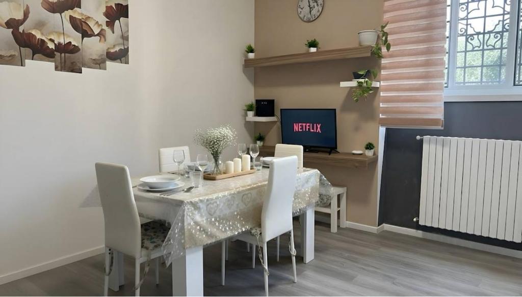 una sala da pranzo con tavolo, sedie e televisione di 10 minutes from the city center private parking Wi-Fi a Monza
