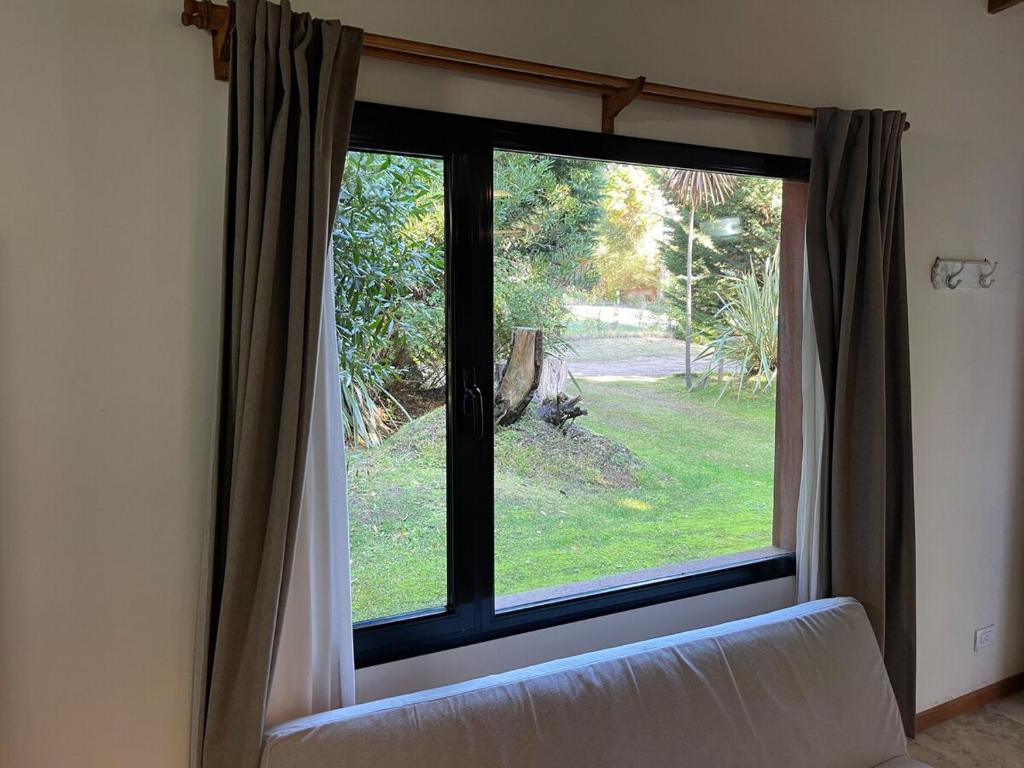 een raam met een bank ervoor bij Bosque y Playa en casa in Carilo