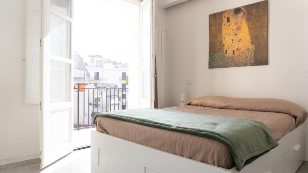 een slaapkamer met een bed met een schilderij aan de muur bij Aerial House in Palermo