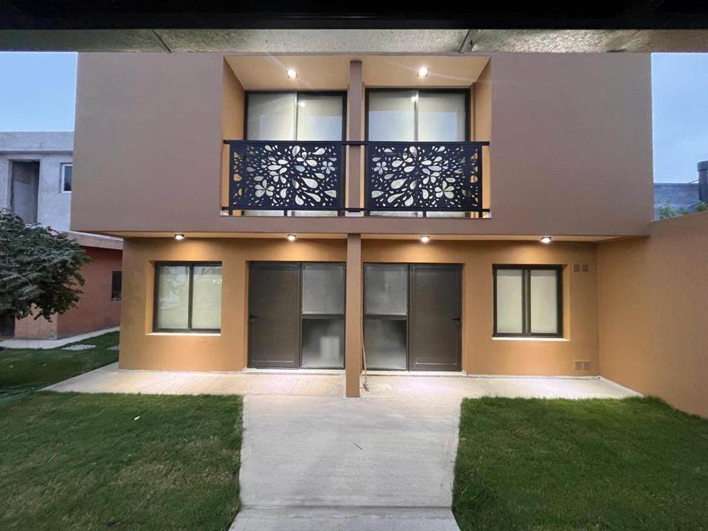 a large house with a balcony and a lawn at Remanso in Alta Gracia