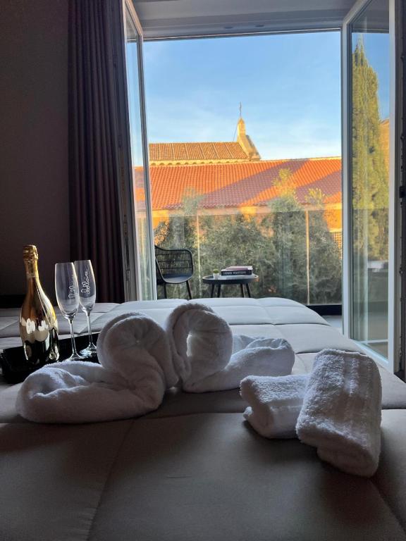 a hotel room with towels on a bed with a large window at 50 Passi dal Duomo in Marcianise