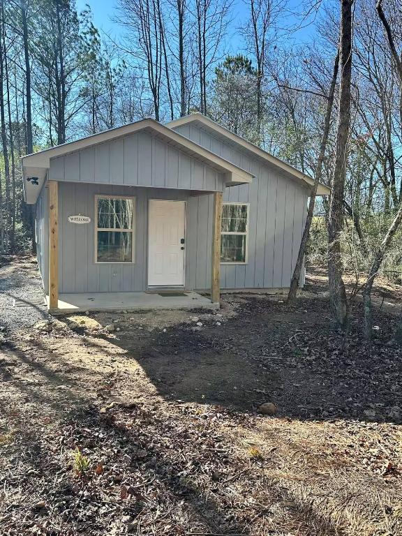 een klein huis met een garage in het bos bij Willow Oak Cottage in Fort Payne