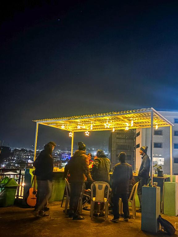a group of people sitting at a bar at night at Stargaze Backpackers Shillong in Shillong