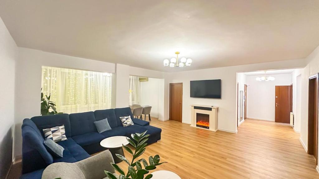 a living room with a blue couch and a fireplace at Zarii Suites- Cotroceni in Bucharest
