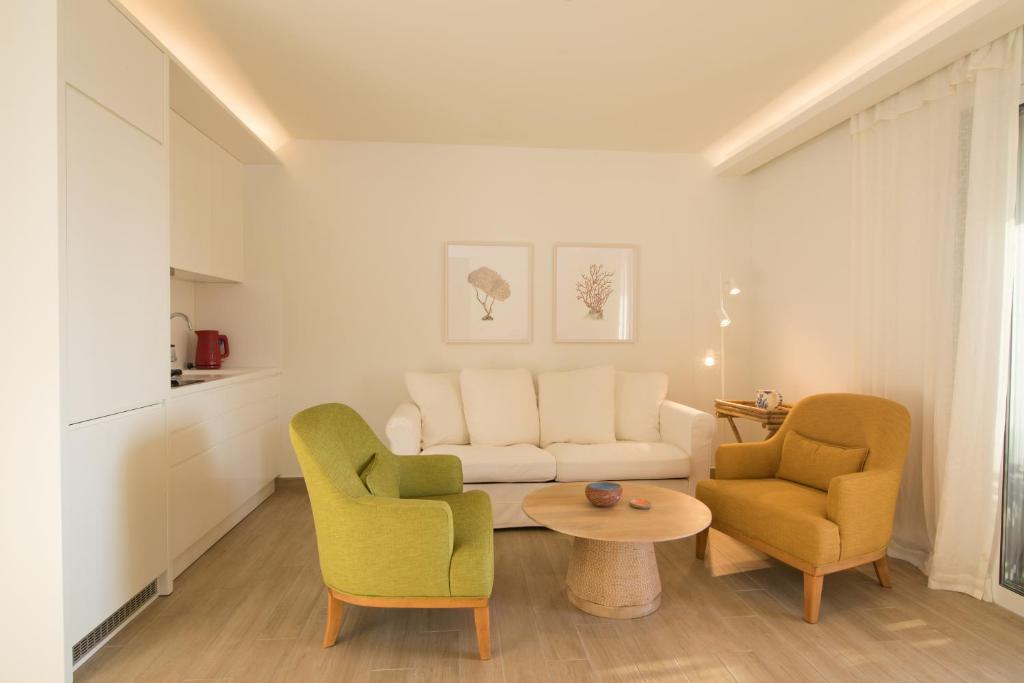 a living room with two chairs and a couch at Glyfada Glow Suites by CorfuEscapes in Glyfada