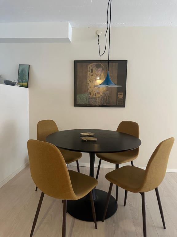 ein Esszimmer mit einem schwarzen Tisch und Stühlen in der Unterkunft Apartment near Utzon in Aalborg