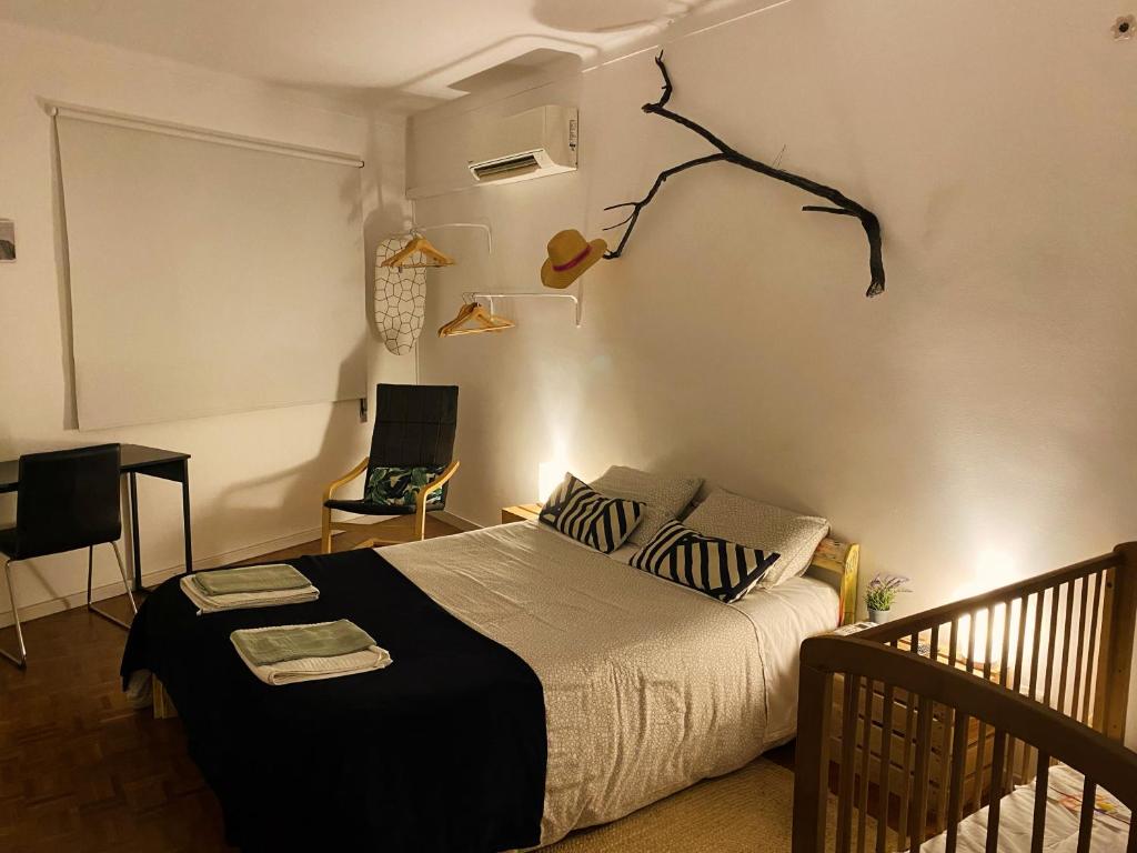 een slaapkamer met een bed, een bureau en een lamp bij Bordallo's Lodge - centro Caldas da Rainha in Caldas da Rainha