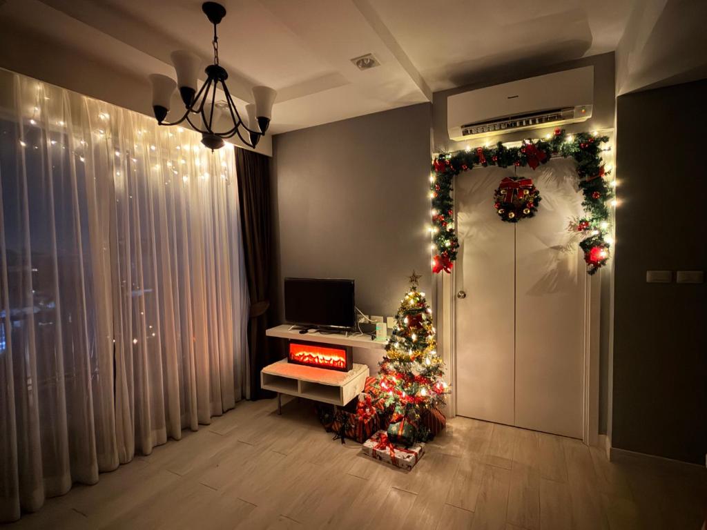 een kamer met een kerstboom en een deur bij The patio บางแสน in Ban Bang Saen (1)