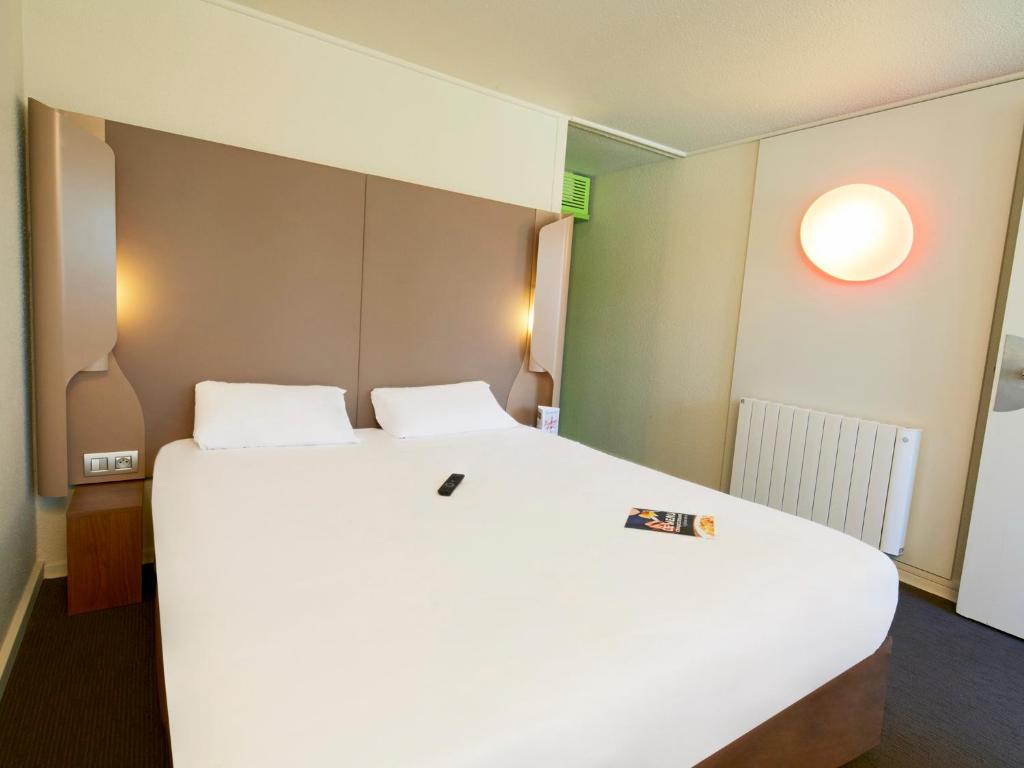 Campanile Dijon Sud - Marsannay في مارساناي-لا-كوت: غرفة نوم مع سرير أبيض كبير في غرفة