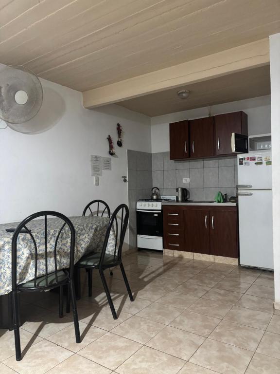 een keuken met een tafel, stoelen en een koelkast bij Complejo El Guri in Colón