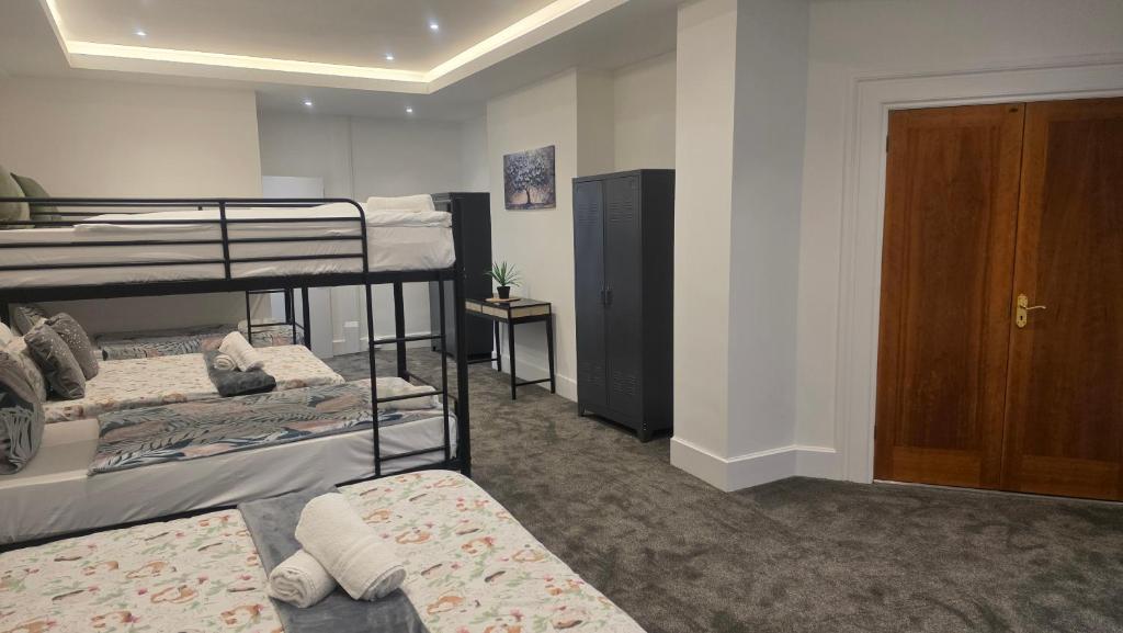 a dorm room with two bunk beds and a door at Royal House by Bourne Hall in Bournemouth