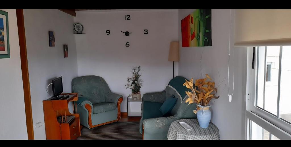 ein Wohnzimmer mit zwei Stühlen und einem Fernseher in der Unterkunft Casa da Tita 