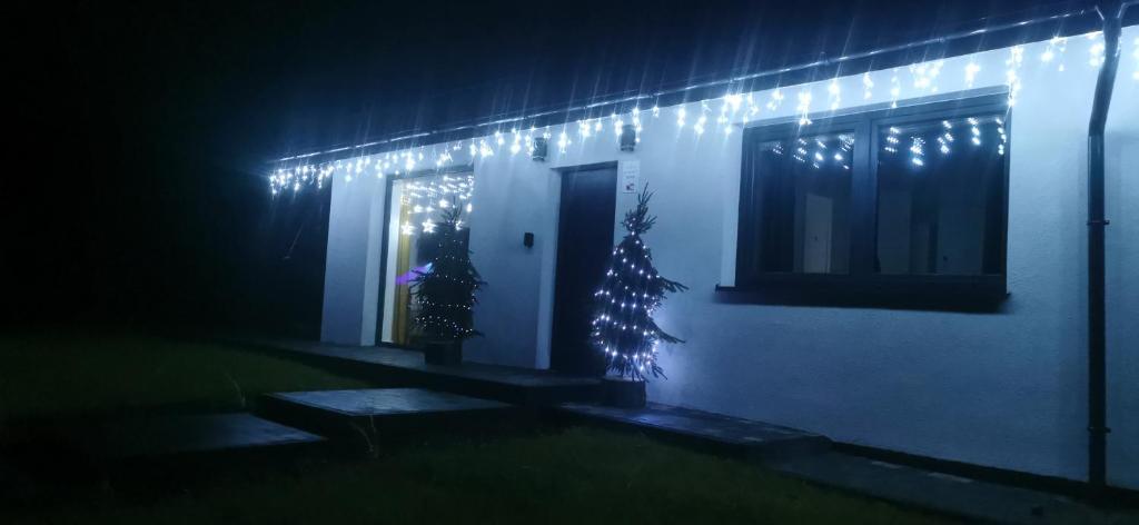 een huis met een kerstboom en verlichting bij W Małym Sadzie in Dobra