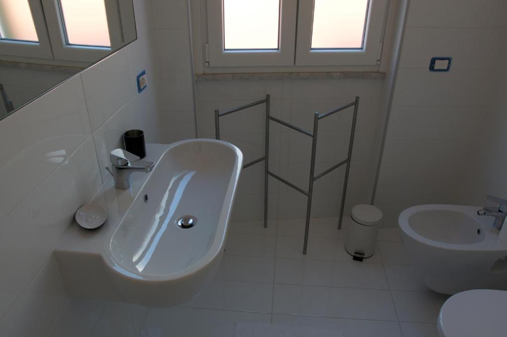a white bathroom with a sink and a toilet at Casa Maria in Salerno