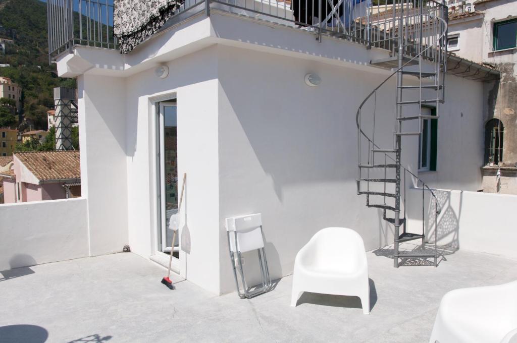 a white chair sitting on a patio next to a building at Casa Maria in Salerno