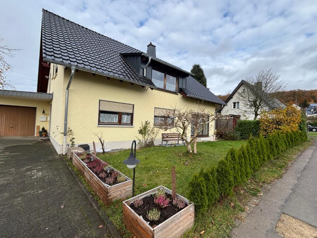 een huis met twee bloemperken ervoor. bij Ferienwohnung Gaber in Reichshof 