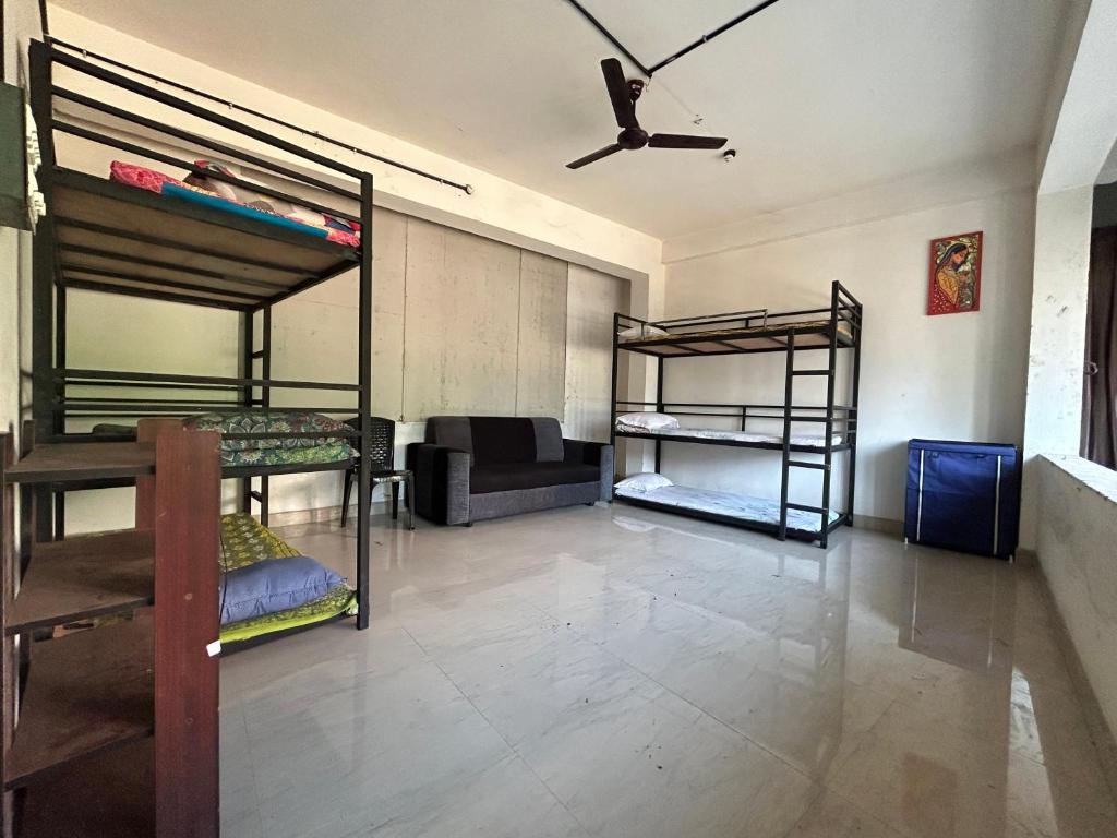 a room with three bunk beds and a ceiling fan at Sabari Rooms in Erumeli