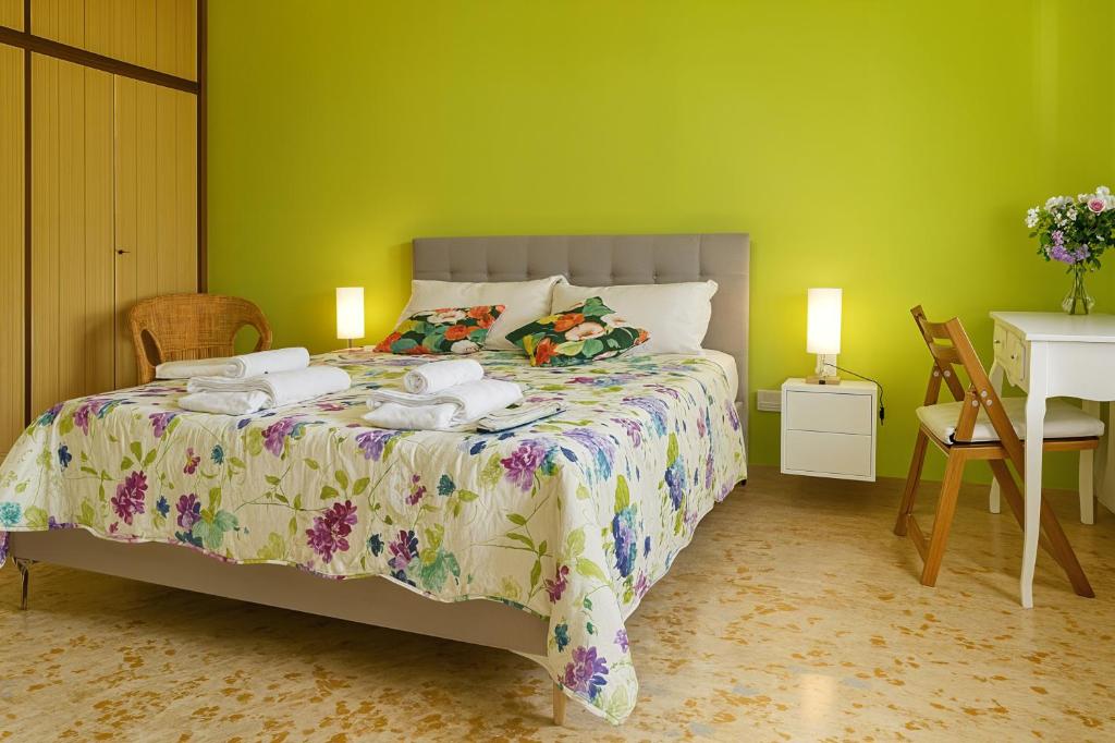 a bedroom with a bed and a green wall at Camera Verde vicino alle Mura - Madame Fannj in Lucca