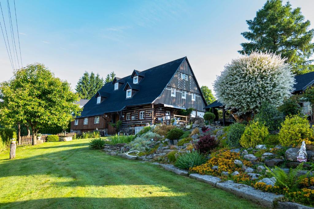 een groot huis met een tuin ervoor bij Jizerská roubenka in Bohdalovice