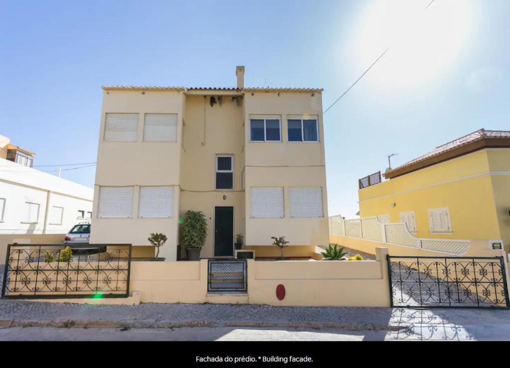 een gebouw met een hek ervoor bij Blife Mariangya private rooms at Faro beach in Faro