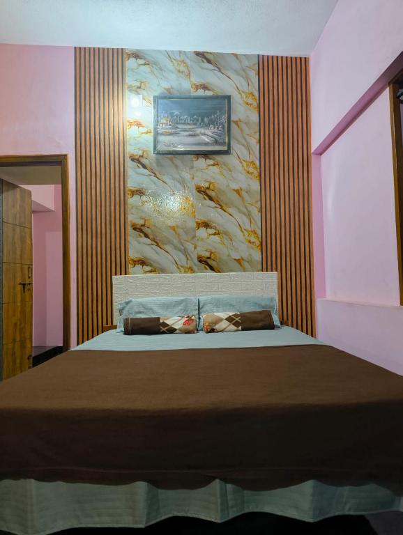 a bedroom with a bed with a painting on the wall at MAHASATHI HOMESTAY Murdeshwar in Māvalli