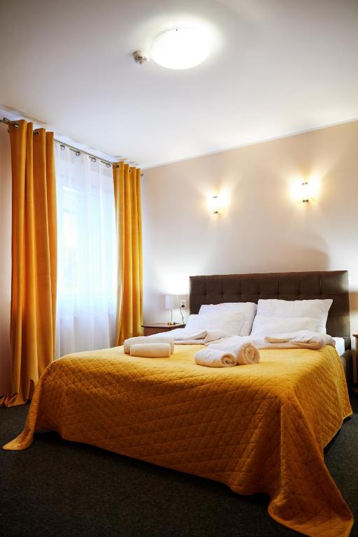 a bedroom with a large bed with towels on it at PLATINIUM House ex Royal House in Białogard