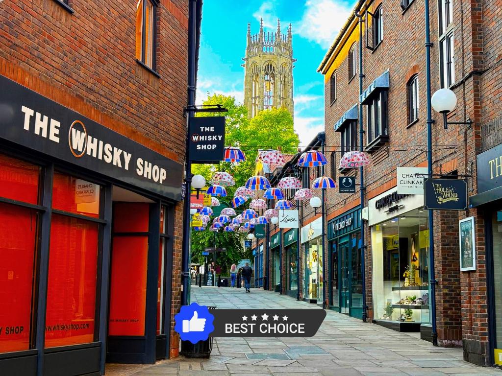 een stadsstraat met veel winkels en een klokkentoren bij York City Centre Flat with view - Best Location - Walk to Everything in York