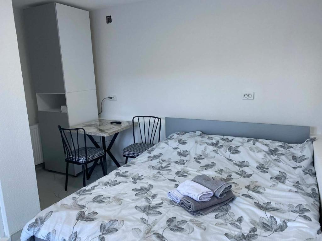 een slaapkamer met een bed, een tafel en stoelen bij Tin-Nik Apartments in Kruševo