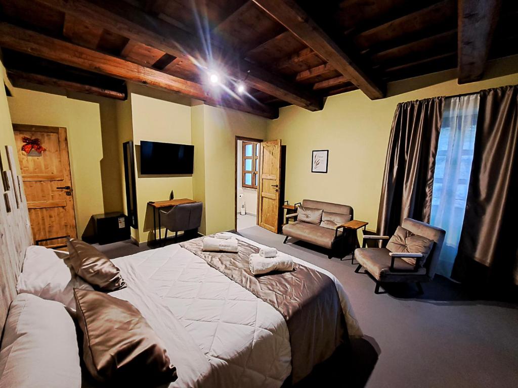 een slaapkamer met een groot bed en twee stoelen bij IL MOLINO del SIGNORE in Pergola