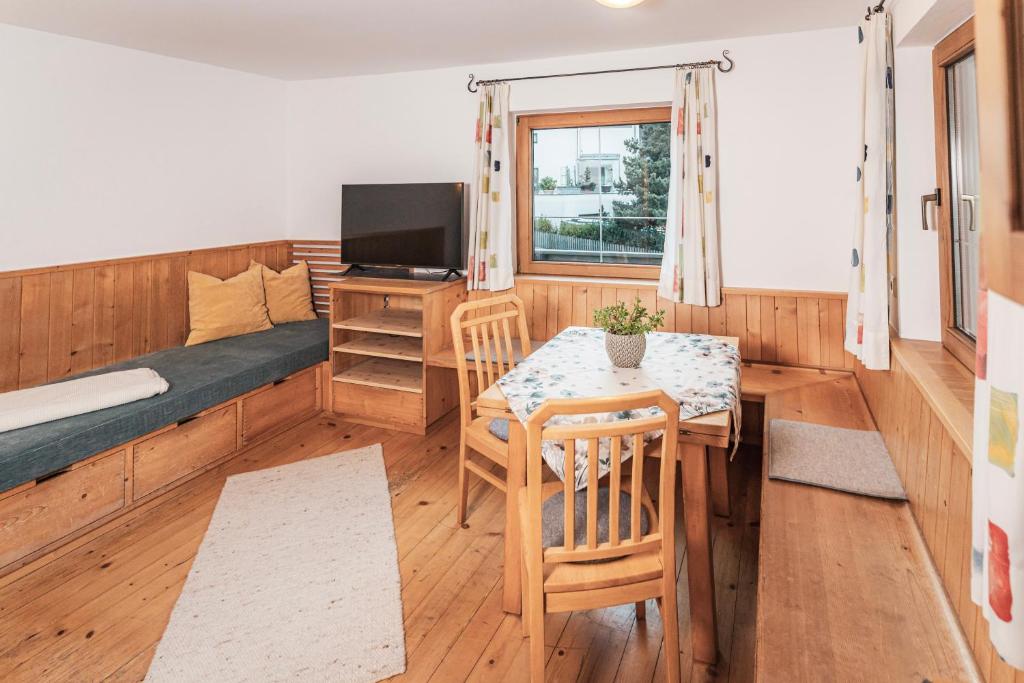 een kleine kamer met een tafel, een bed en een televisie bij Ferienhaus Lotta in Umhausen