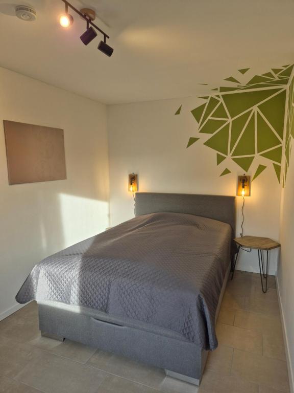 una camera con un letto in una stanza con un muro di Ferienwohnung - ZeitRaum a Gemünden