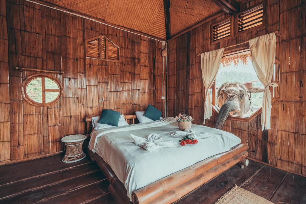 ein Schlafzimmer mit einem Bett in einem Holzzimmer in der Unterkunft Lazy mango homestay in Ban Mae Sapok Nua