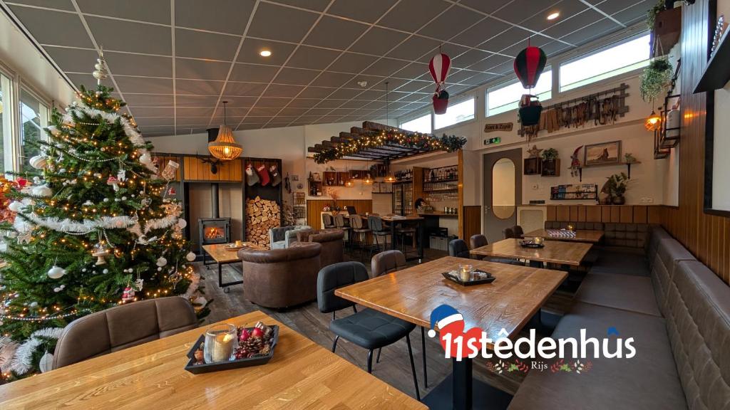 ein Weihnachtsbaum im Speisesaal eines Restaurants in der Unterkunft 11Stedenhuis in Rijs