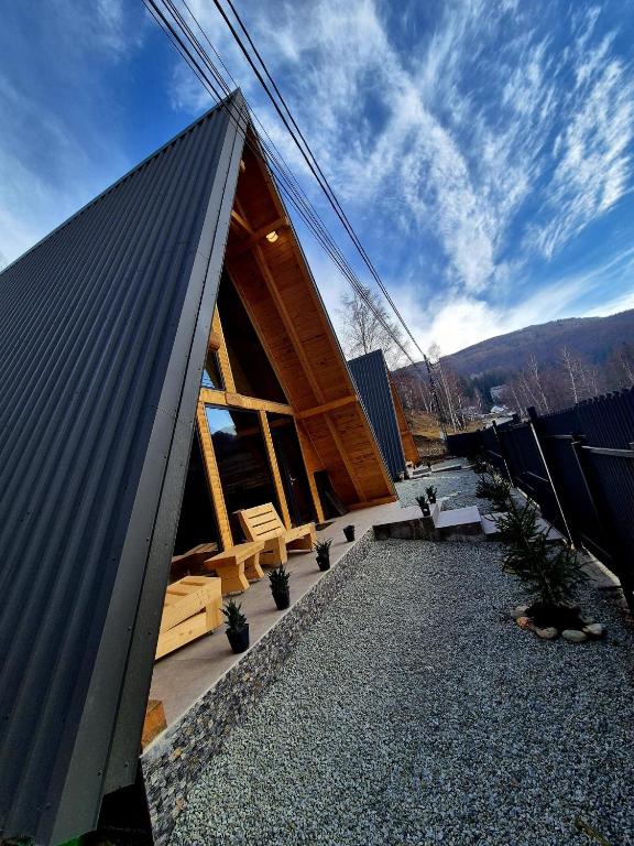 a building with a gambrel roof on top of it at Amurg in Lupeni